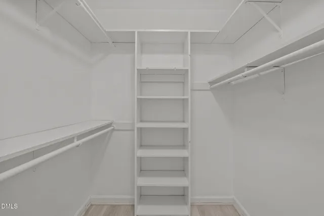 a view of walk in closet with empty racks