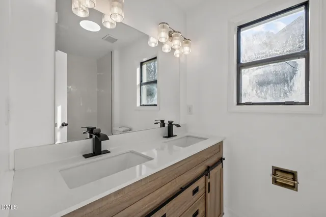 a bathroom with a sink a large mirror and vanity