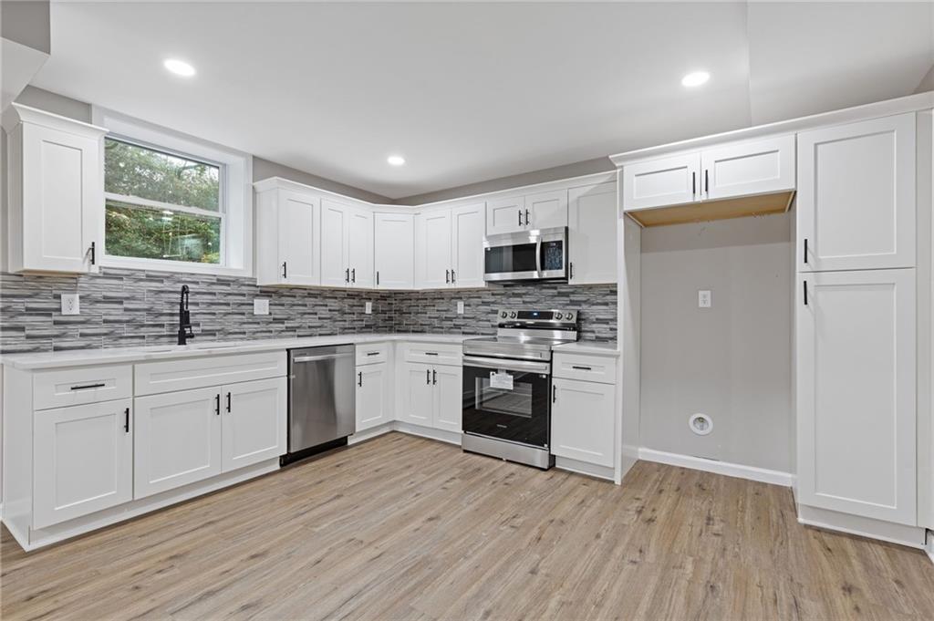 2224 Hudson Drive Southwest Lilburn, GA 30047 - Photo 21 of 30 a kitchen with granite countertop white cabinets and white appliances