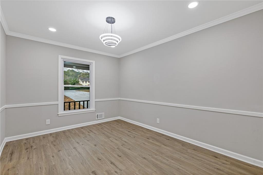 2224 Hudson Drive Southwest Lilburn, GA 30047 - Photo 7 of 30 an empty room with wooden floor and windows