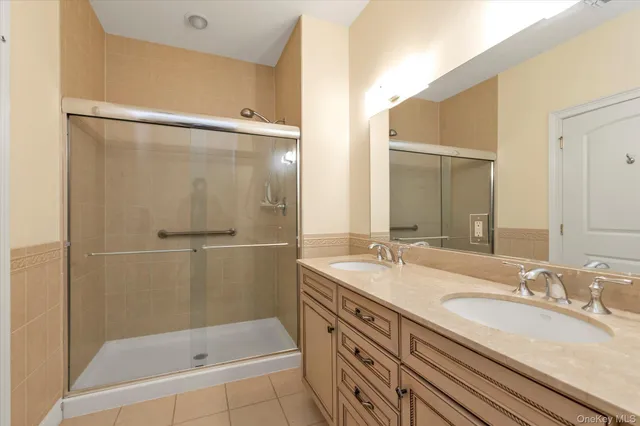 a bathroom with a granite countertop sink mirror and shower