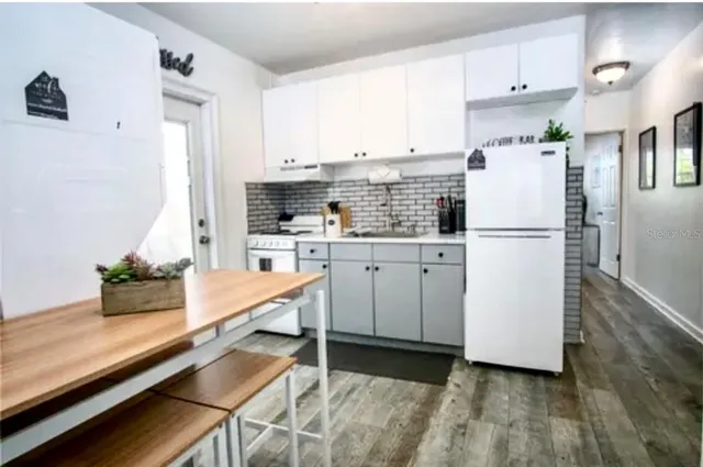 a kitchen with white cabinets and white appliances