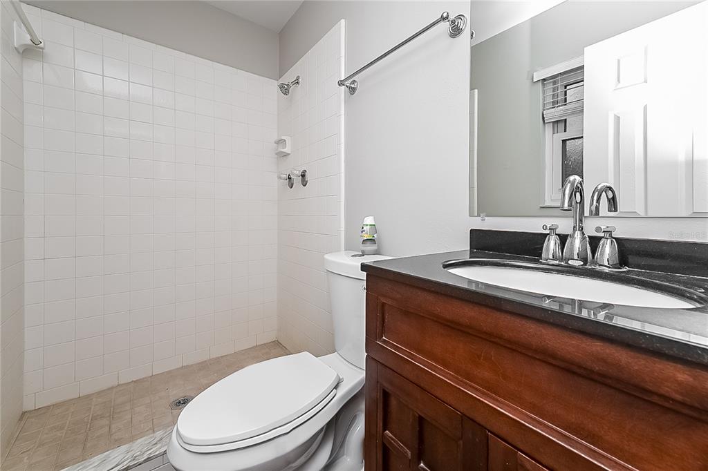 6416 Chippendale Road Lakeland, FL 33809 - Photo 11 of 16 a bathroom with a granite countertop toilet sink and mirror