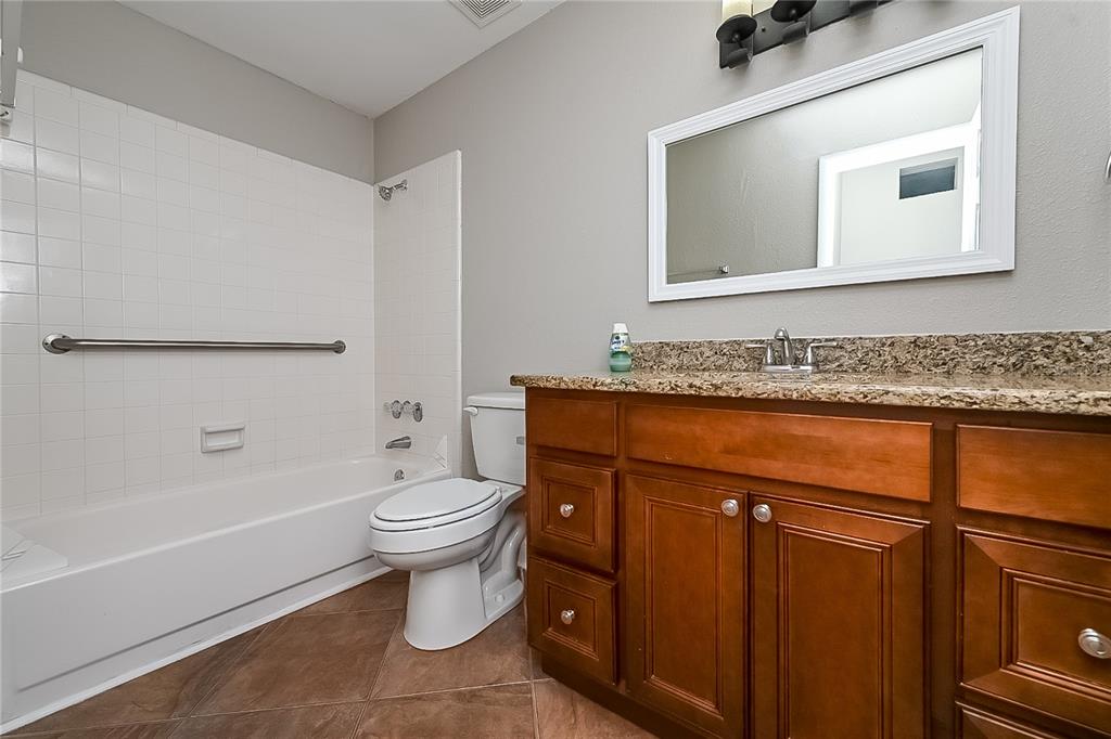 6416 Chippendale Road Lakeland, FL 33809 - Photo 14 of 16 a bathroom with a granite countertop toilet sink and mirror