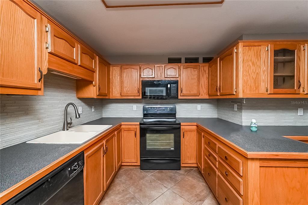 6416 Chippendale Road Lakeland, FL 33809 - Photo 6 of 16 a kitchen with stainless steel appliances granite countertop a sink stove and microwave