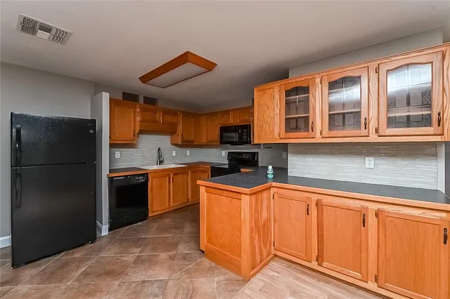 a kitchen with stainless steel appliances granite countertop a refrigerator and a sink