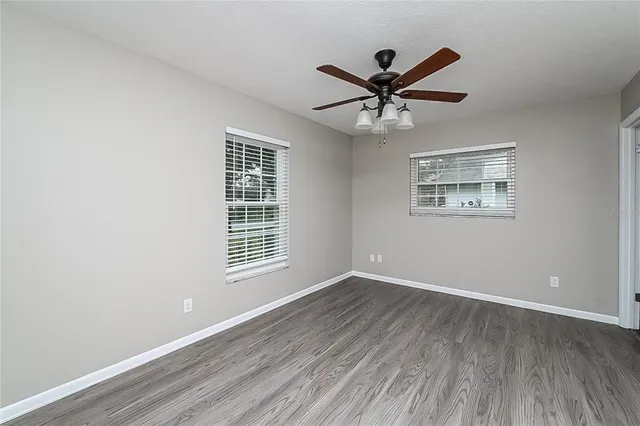 a view of a big room with wooden floor and windows