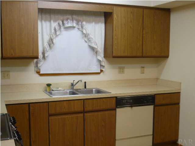 SECOND VIEW OF KITCHEN ALL ELECTRIC WITH DISHWASHER, ELECTRIC STOVE AND REFRIGERATOR. UTILITY ROOM IS OFF TO THE RIGHT