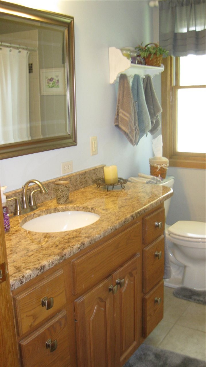 5549 North Stillman Road Stillman Valley, IL 61084 - Photo 17 of 22 a bathroom with a granite countertop sink and a mirror