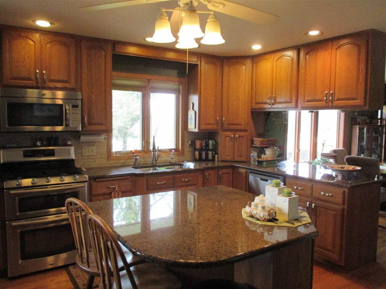 5549 North Stillman Road Stillman Valley, IL 61084 - Photo 6 of 22 a kitchen with kitchen island granite countertop a sink and a stove