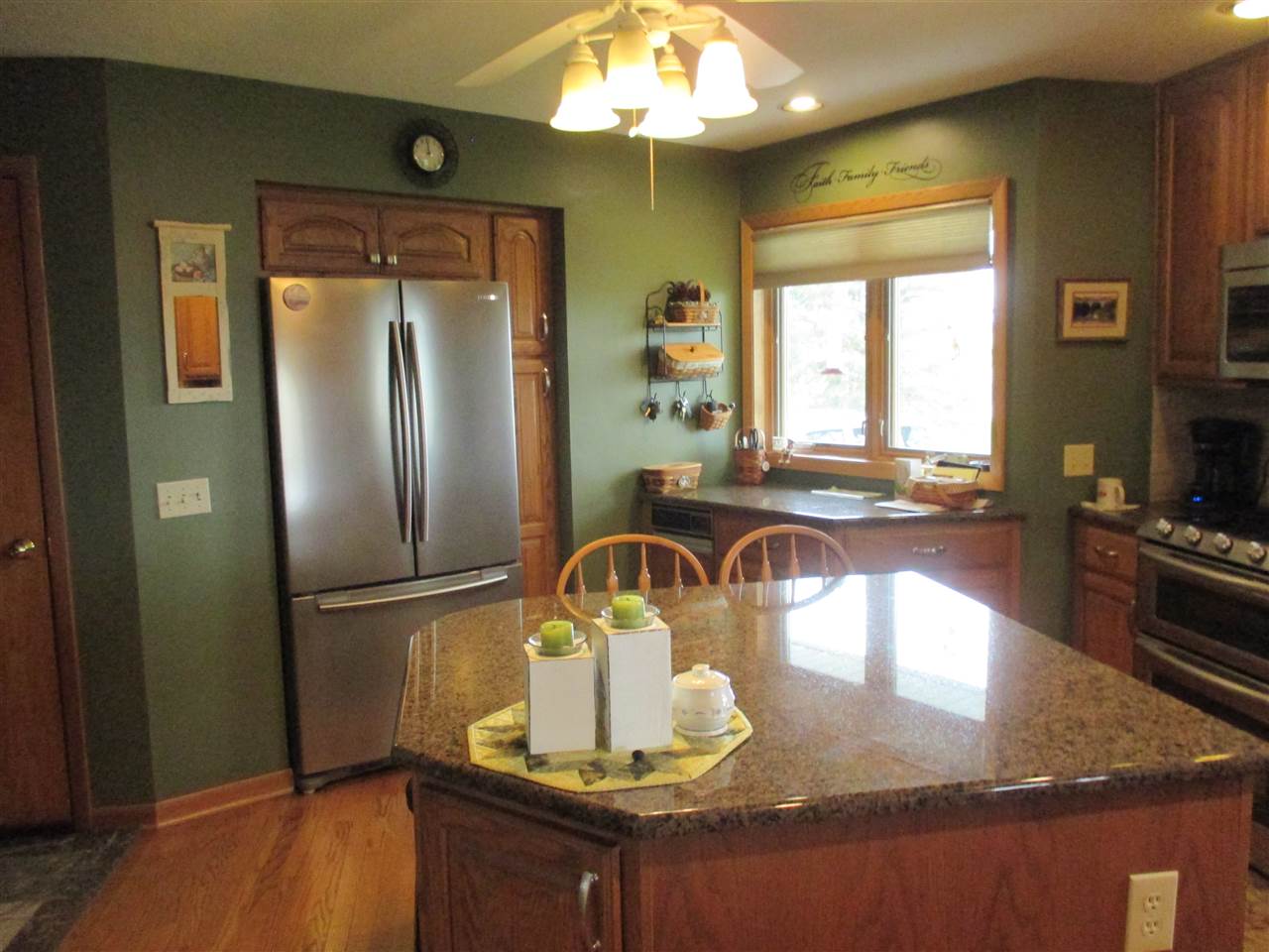 5549 North Stillman Road Stillman Valley, IL 61084 - Photo 7 of 22 a kitchen with a refrigerator a stove and a sink with wooden floor
