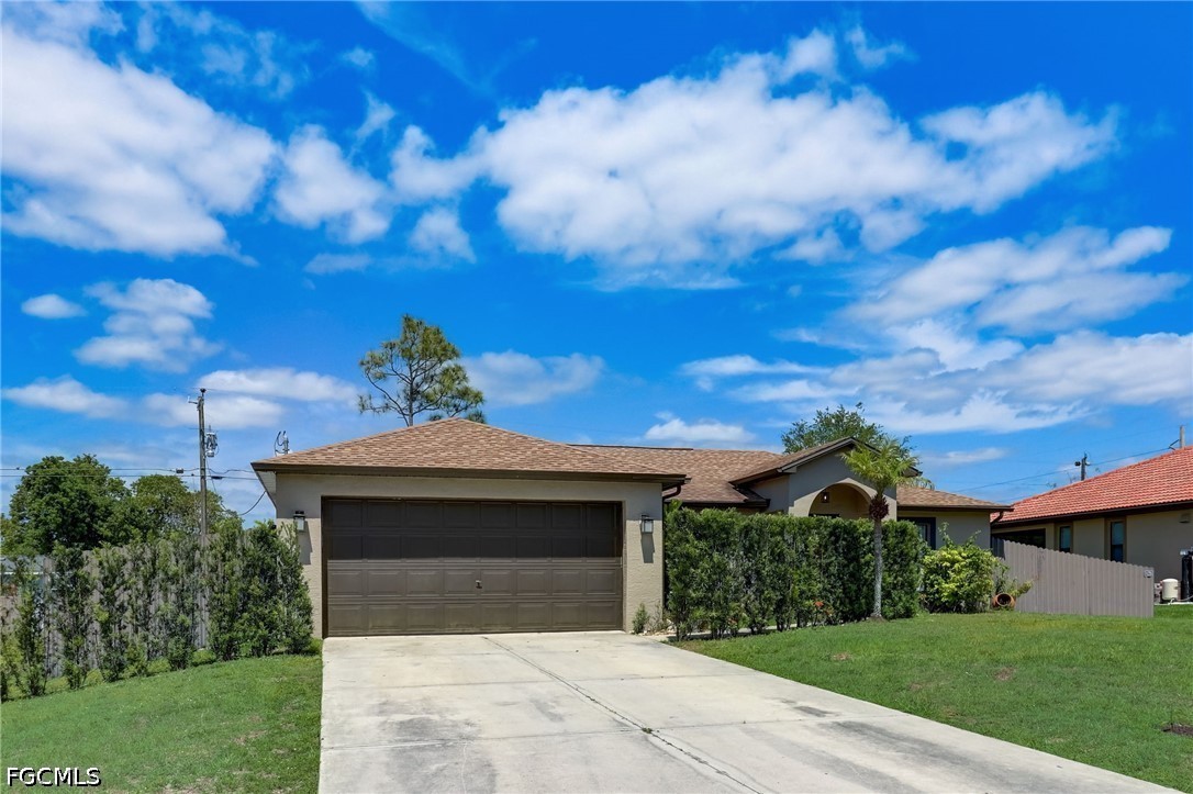 4402 3rd Street West Lehigh Acres, FL 33971 - Photo 1 of 4 a front view of a house with a garden