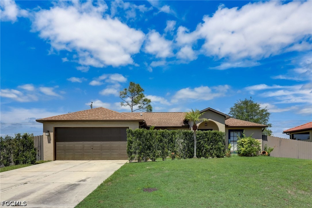 4402 3rd Street West Lehigh Acres, FL 33971 - Photo 2 of 4 a front view of a house with a garden