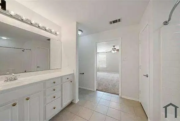 a spacious bathroom with a double vanity sink a mirror and a shower