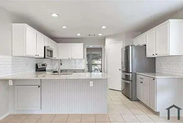 a kitchen with stainless steel appliances granite countertop a refrigerator and a stove top oven