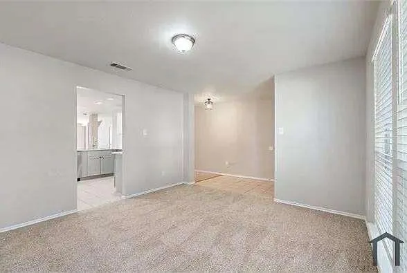 an empty room with a bathroom and a window