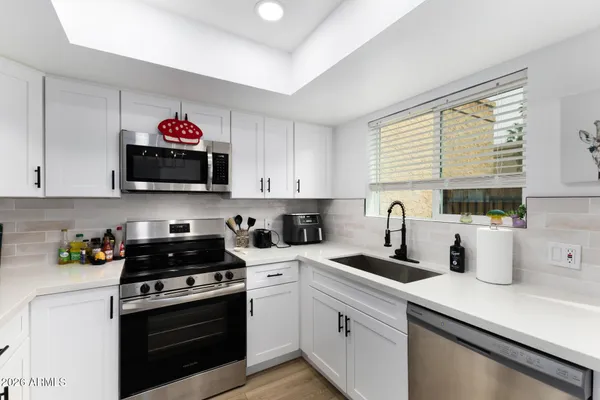 a kitchen with a sink a stove and cabinets