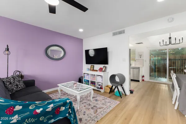 a living room with furniture a flat screen tv and a floor to ceiling window