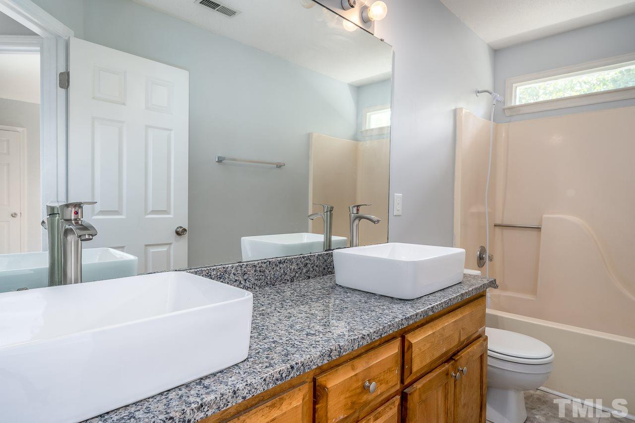 4500 Knightsbridge Way Raleigh, NC 27604 - Photo 18 of 24 a spacious bathroom with a granite countertop sink a toilet a mirror and shower