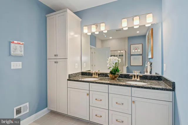 a bathroom with double sink and a mirror