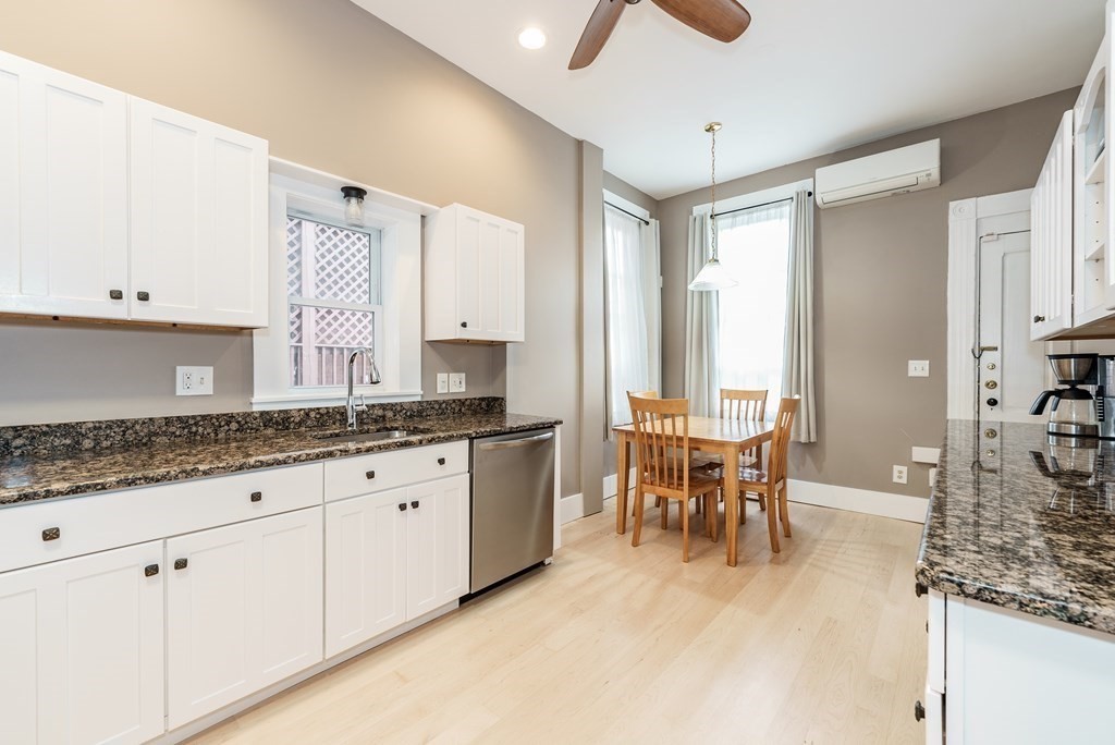 19 Mattoon Street Springfield, MA 01105 - Photo 14 of 42 a large white kitchen with granite countertop a sink and dishwasher a stove with wooden floor