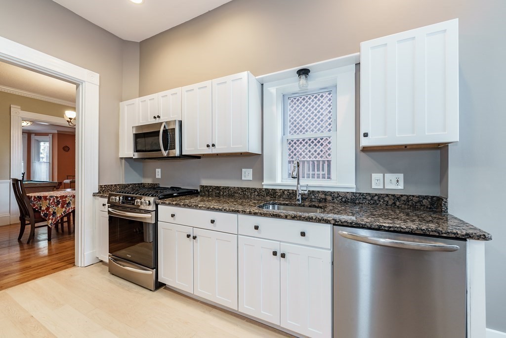 19 Mattoon Street Springfield, MA 01105 - Photo 19 of 42 a kitchen with stainless steel appliances granite countertop a stove a sink and a microwave