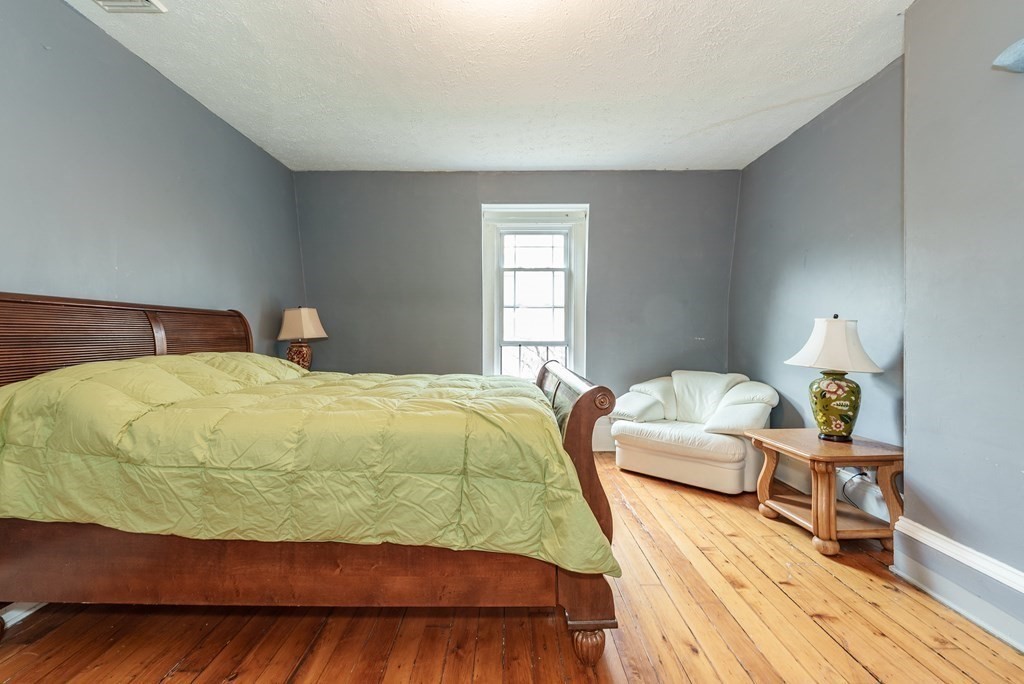 19 Mattoon Street Springfield, MA 01105 - Photo 29 of 42 a bedroom with a bed and wooden floor