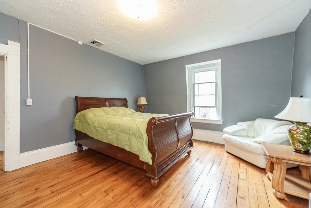 19 Mattoon Street Springfield, MA 01105 - Photo 30 of 42 a bedroom with a bed and wooden floor