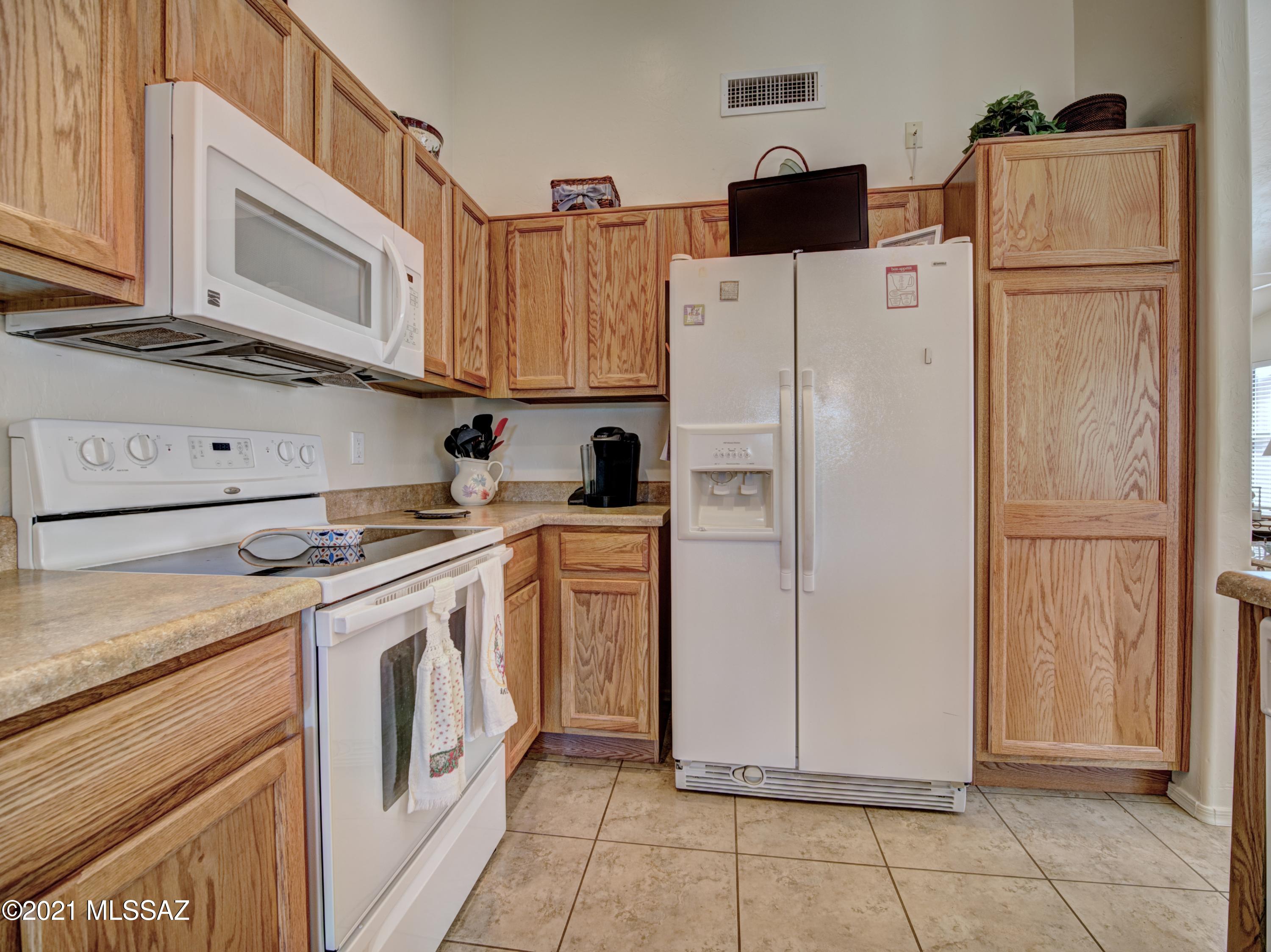434 Colorado Court Rio Rico, AZ 85648 - Photo 14 of 29 a kitchen with a refrigerator a stove top oven and cabinets
