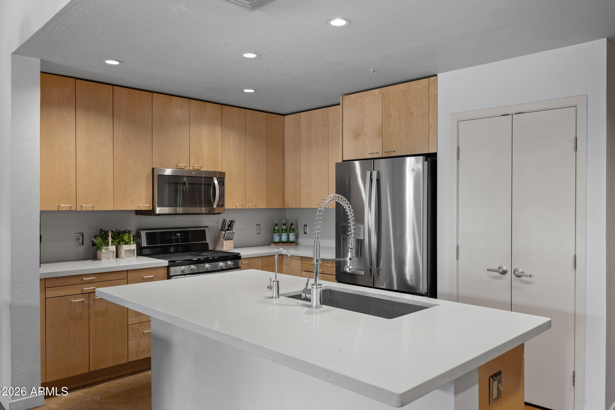 914 East Osborn Road, Unit 216 Phoenix, AZ 85014 - Photo 4 of 26 a kitchen with stainless steel appliances a refrigerator and a stove