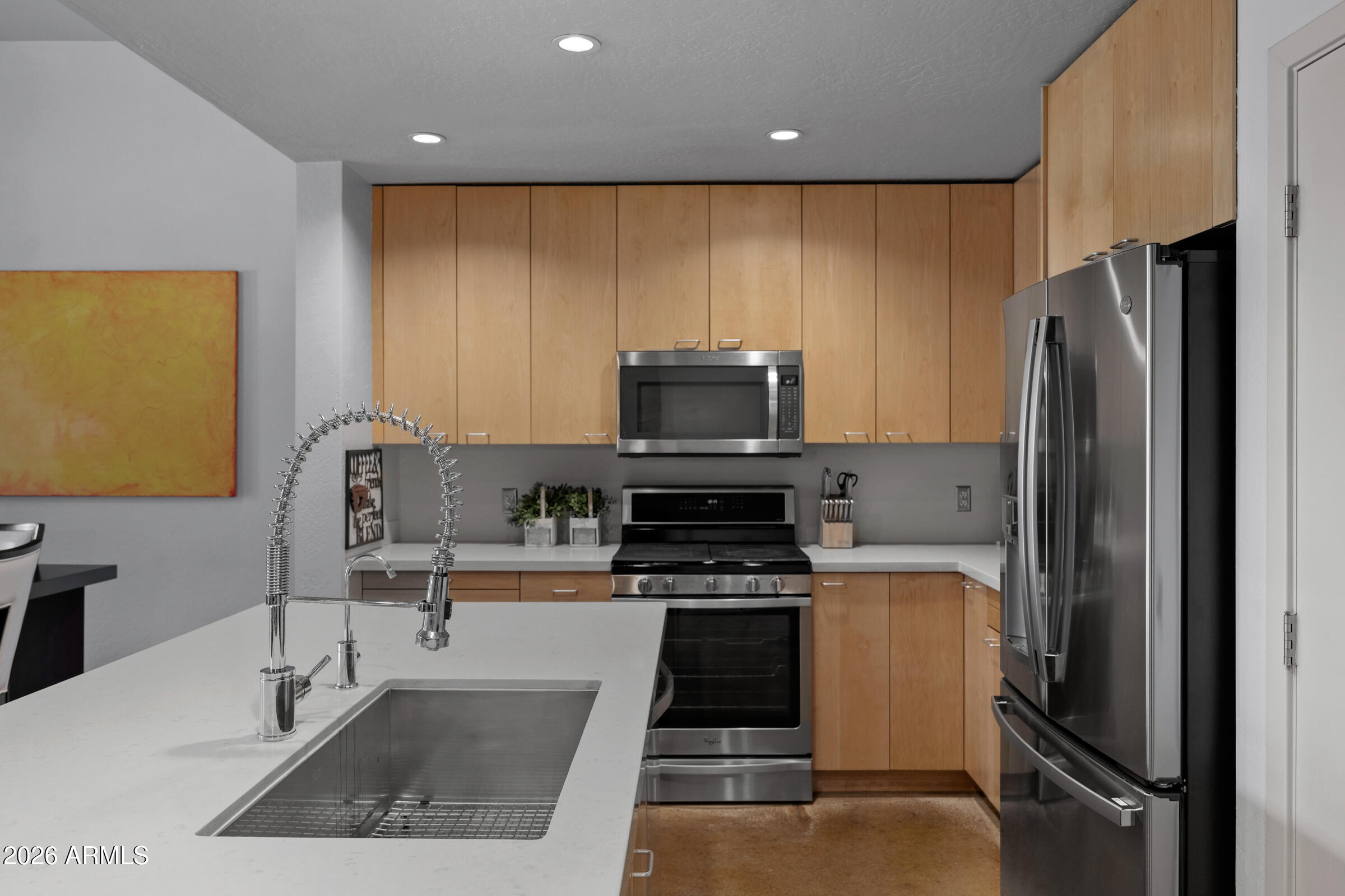 914 East Osborn Road, Unit 216 Phoenix, AZ 85014 - Photo 5 of 26 a kitchen with stainless steel appliances granite countertop a refrigerator and a stove top oven