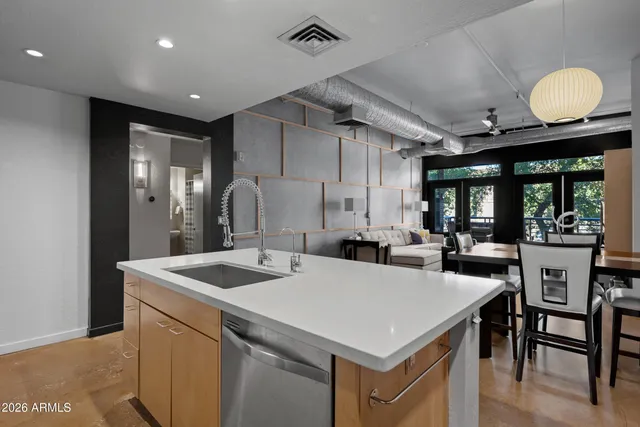 a kitchen that has a sink a table and chairs in it