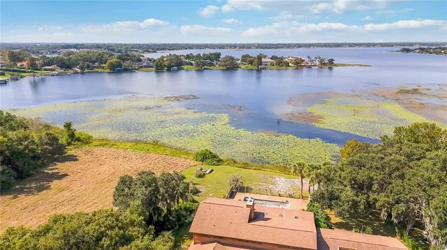 an aerial view of residential houses with outdoor space and lake view