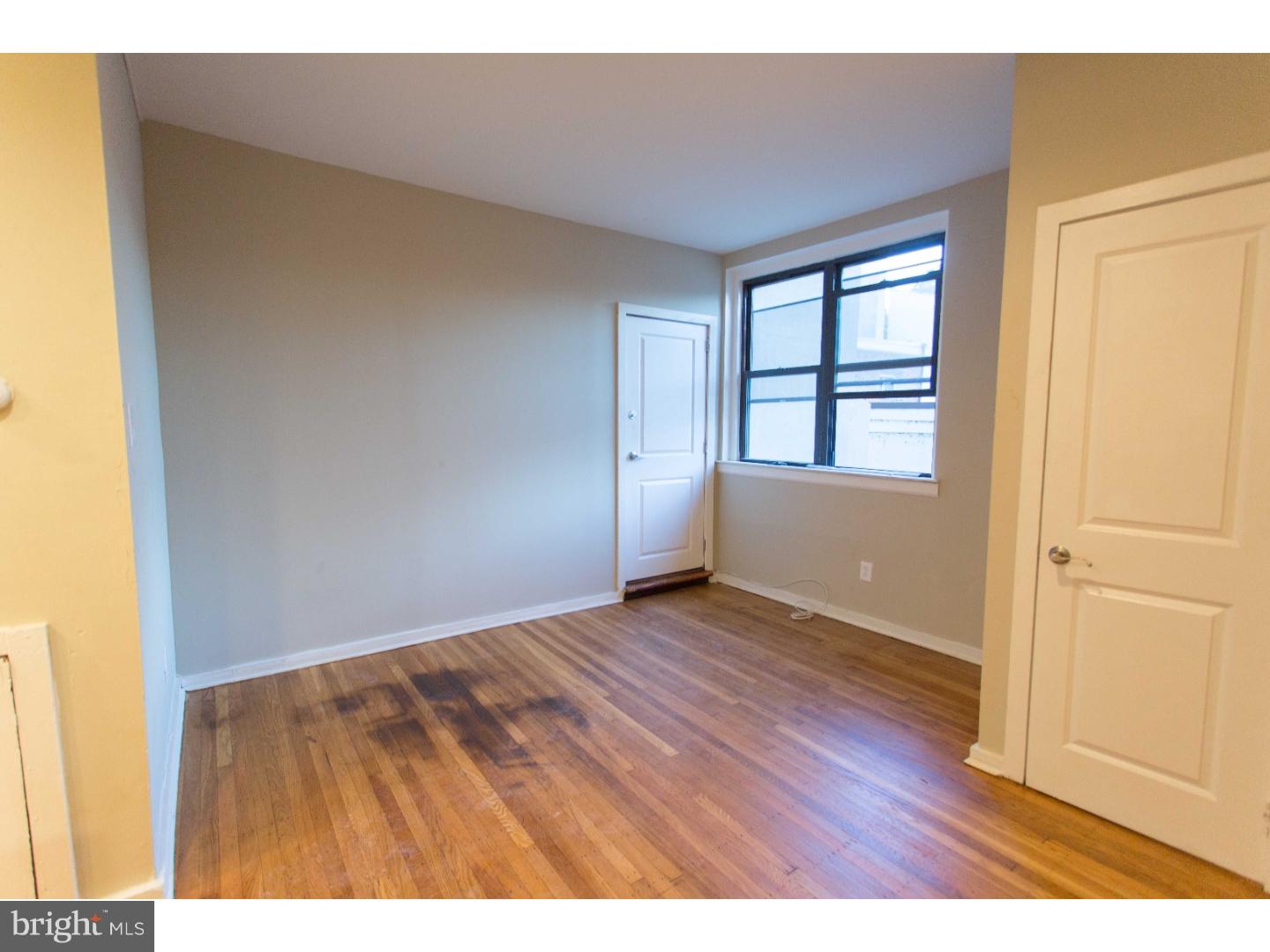 413 South 11th Street, Unit 3F Philadelphia, PA 19147 - Photo 4 of 15 an empty room with wooden floor and windows