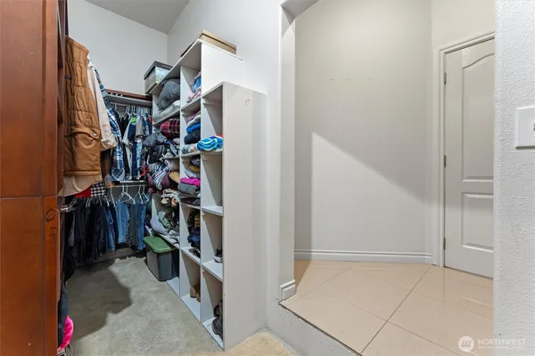 a view of walk in closet with clothes and shoes