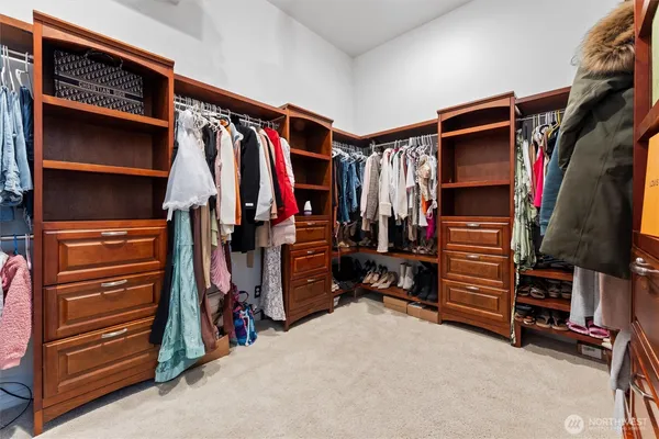 a view of walk in closet with clothes and shoes