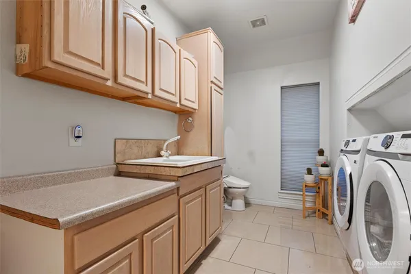 a utility room with sink dryer and washer