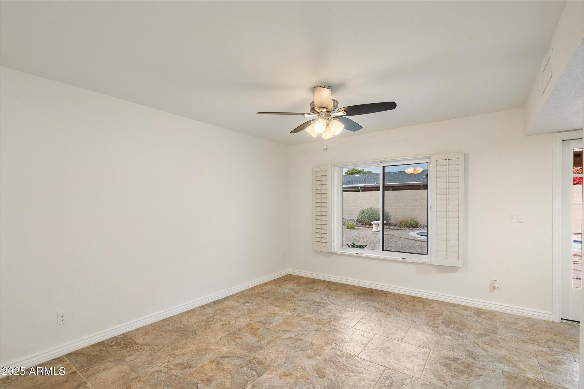 6242 East Hearn Road Scottsdale, AZ 85254 - Photo 11 of 40 an empty room with windows and chandelier fan