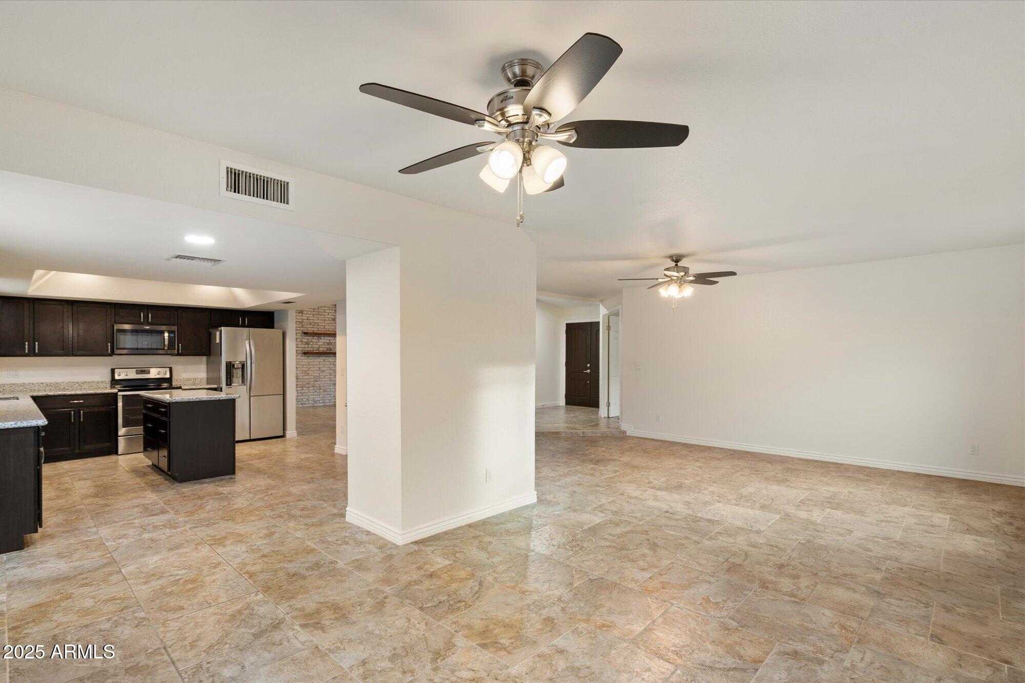 6242 East Hearn Road Scottsdale, AZ 85254 - Photo 15 of 40 a view of a livingroom with a ceiling fan and kitchen