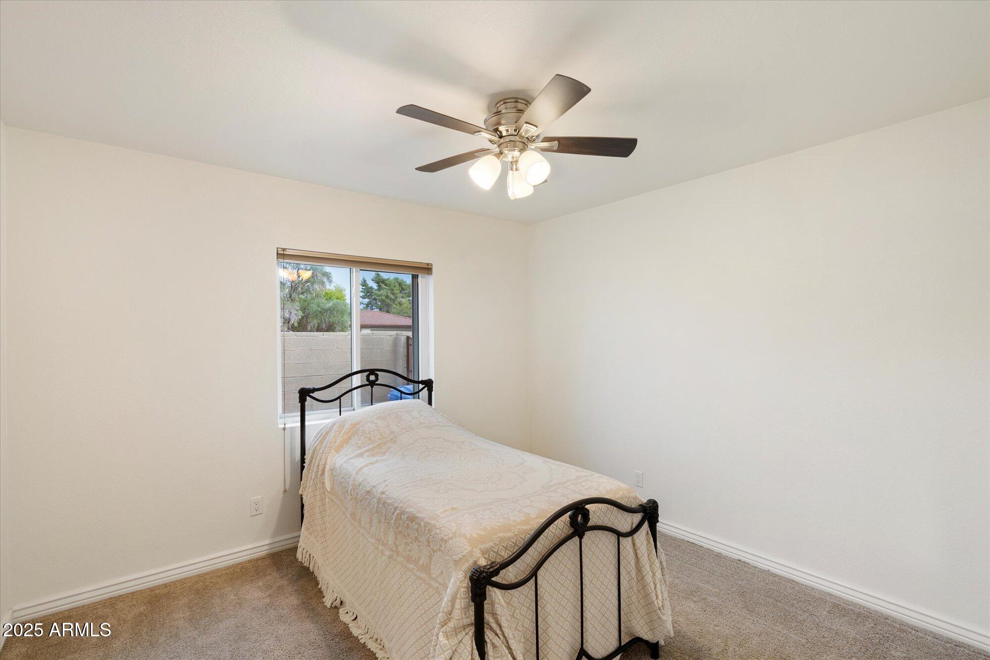 6242 East Hearn Road Scottsdale, AZ 85254 - Photo 21 of 40 a bedroom with a bed and a chandelier