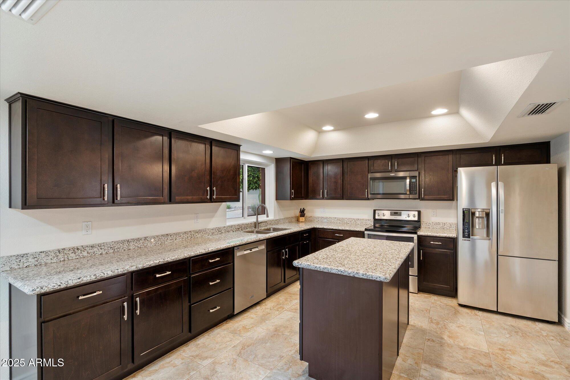 6242 East Hearn Road Scottsdale, AZ 85254 - Photo 9 of 40 a kitchen with stainless steel appliances granite countertop a sink stove and refrigerator