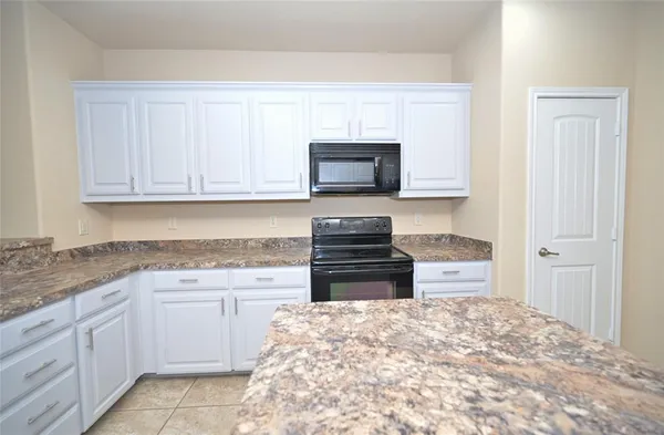 a kitchen with granite countertop a sink and a stove top oven