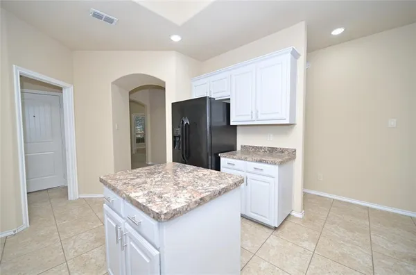 a kitchen with stainless steel appliances granite countertop a refrigerator and a stove top oven