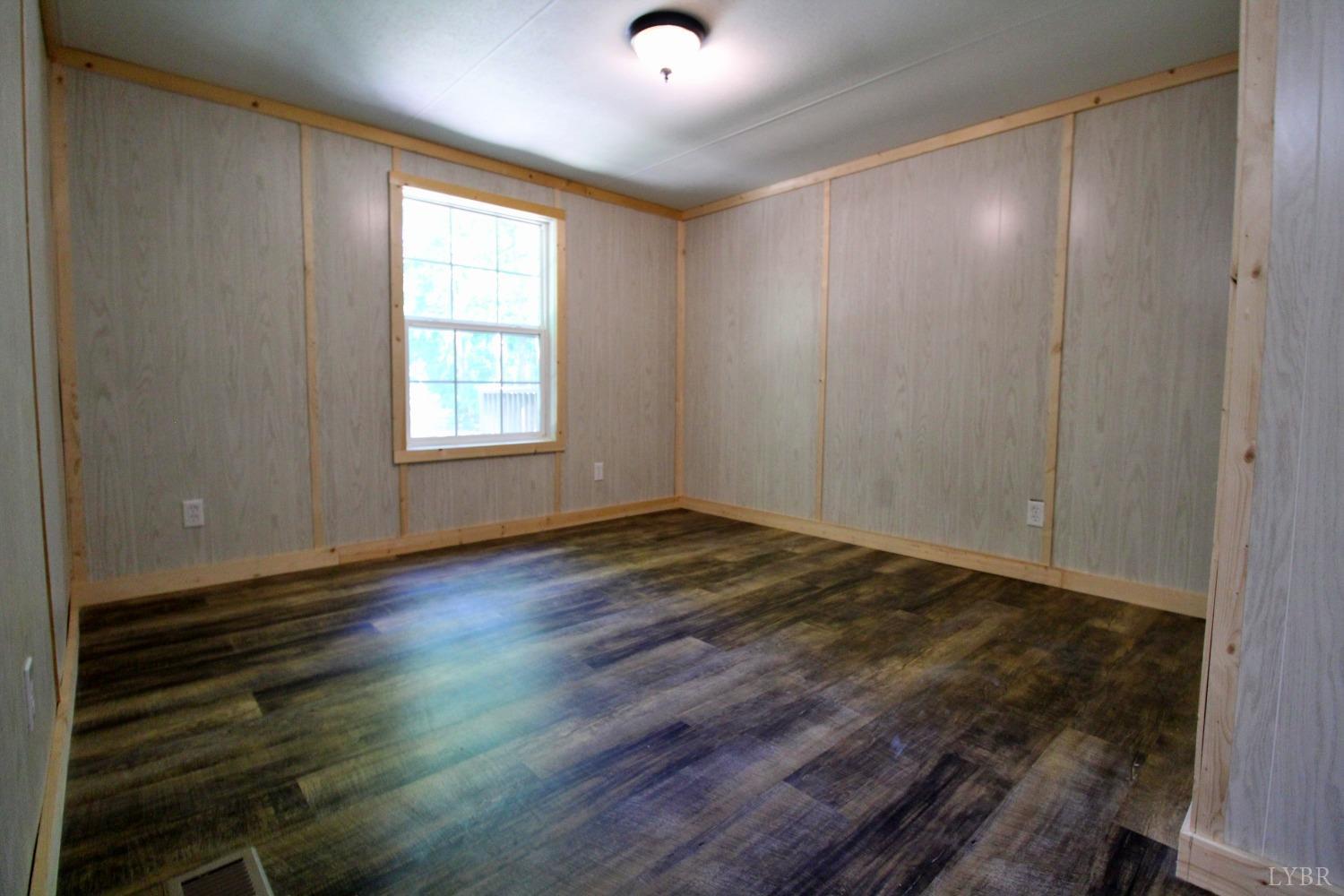 182 Shelton Store Road Wingina, VA 24599 - Photo 23 of 30 an empty room with wooden floor and windows
