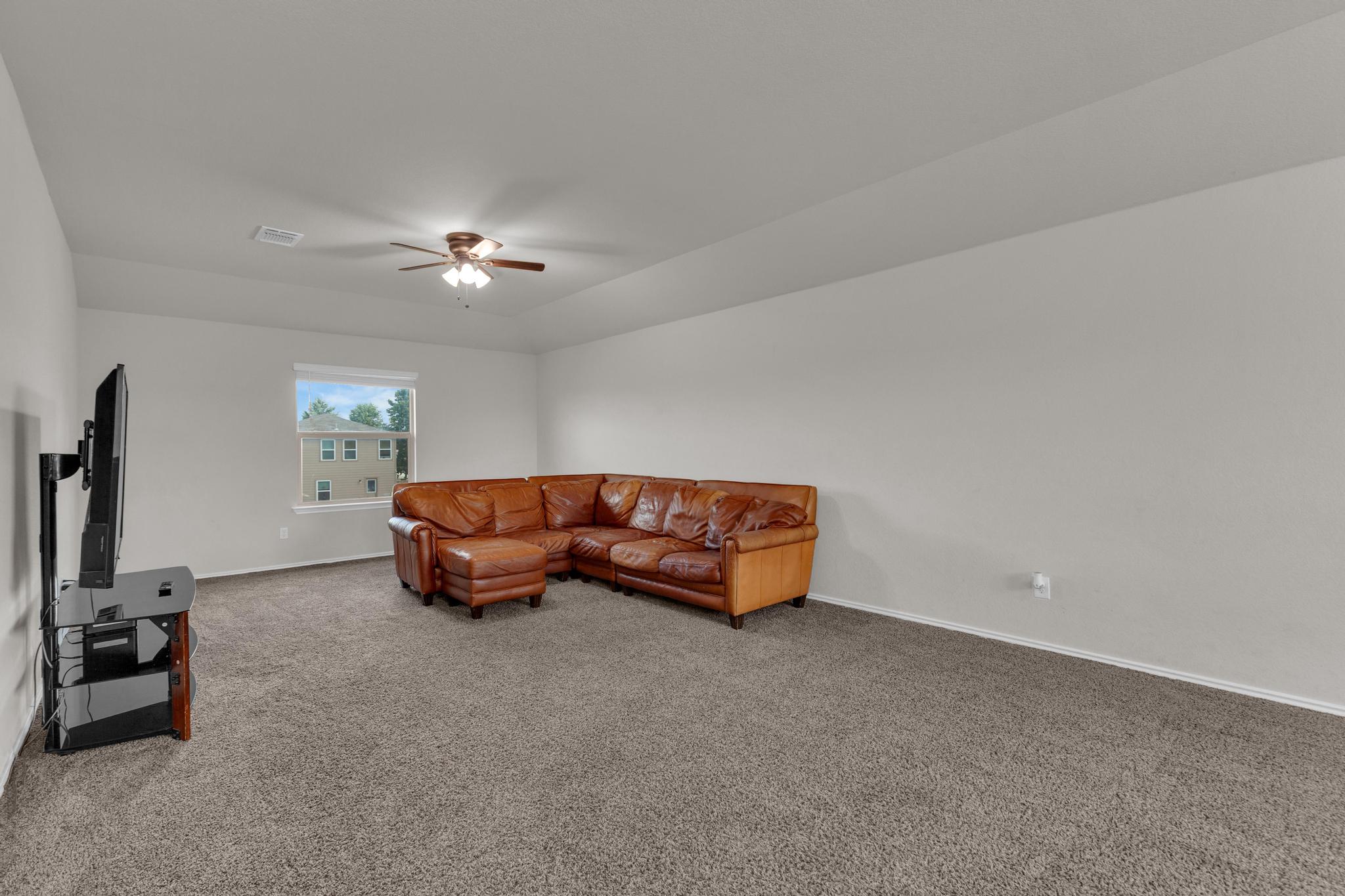 104 Uncle Billy Way Jarrell, TX 76537 - Photo 23 of 38 A spacious living area with ample natural light, featuring comfortable carpet flooring.