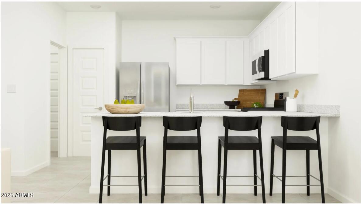 14955 West Hackamore Drive Surprise, AZ 85387 - Photo 2 of 19 a kitchen with stainless steel appliances kitchen island granite countertop a table and chairs