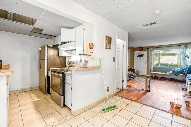 a kitchen with granite countertop a refrigerator and a stove top oven