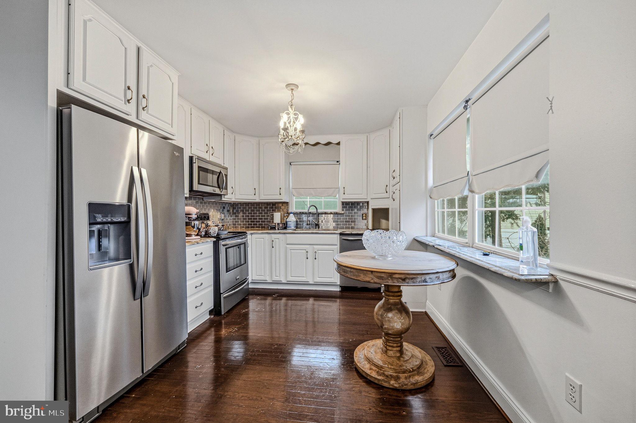 346 Bear Christiana Road Bear, DE 19701 - Photo 15 of 35 a kitchen with stainless steel appliances a table chairs refrigerator and cabinets