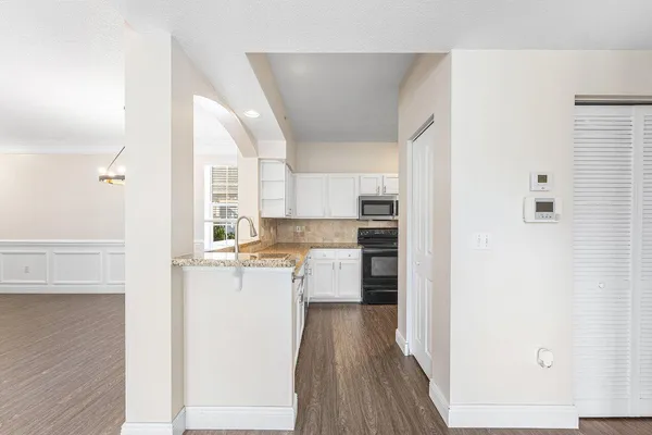 a kitchen with stainless steel appliances granite countertop a sink stove and cabinets