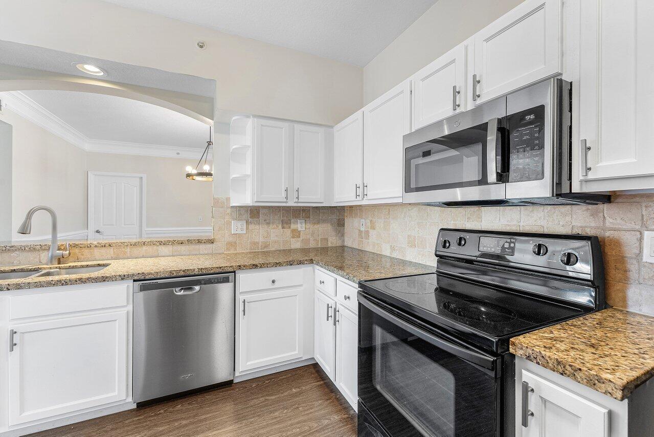 276 Murcia Drive, Unit 301 Jupiter, FL 33458 - Photo 17 of 52 a kitchen with stainless steel appliances granite countertop a stove a sink dishwasher and a microwave oven with white cabinets